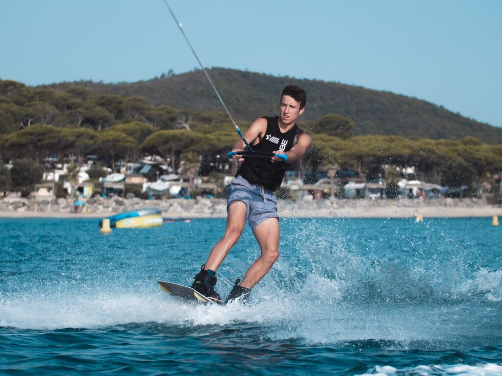 Jeune homme en wake board devant la plage du camping