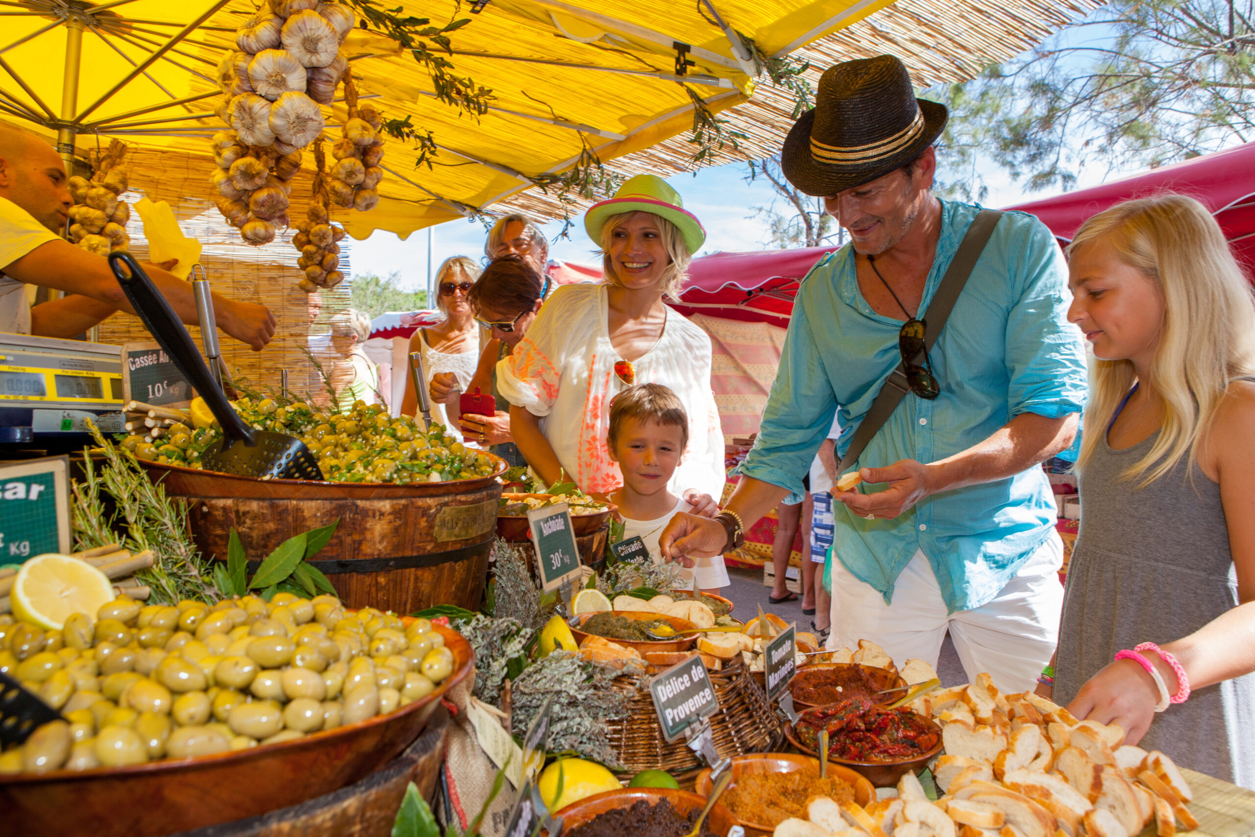 Allée du marché du Lavandou en bord de mer, étals de fruits et fleurs